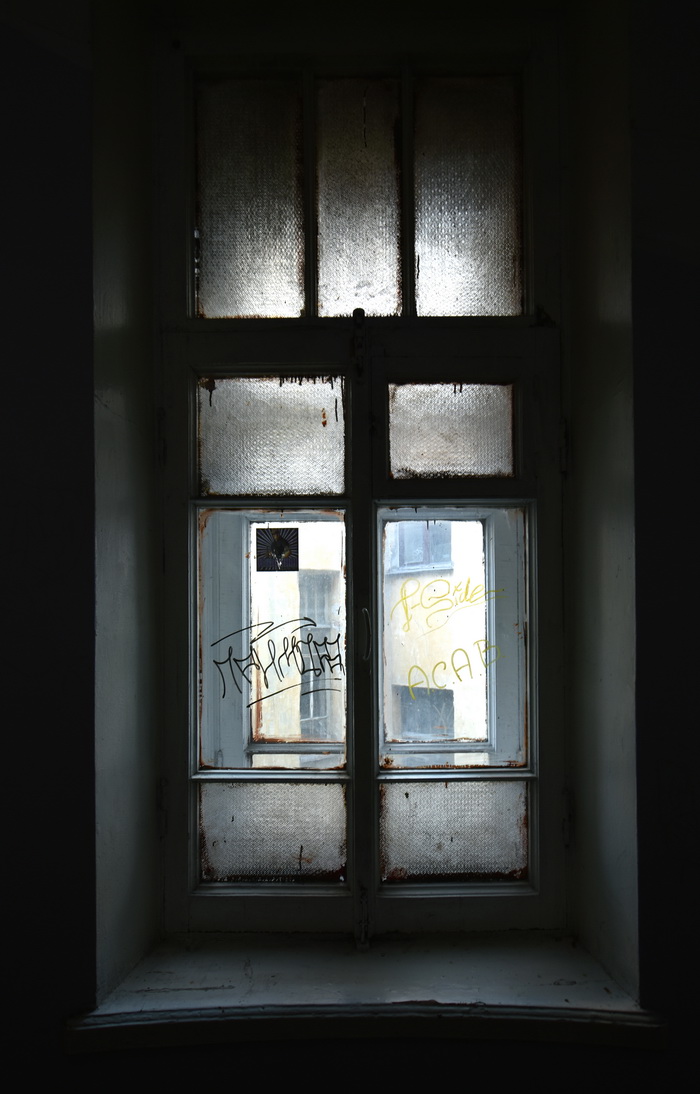 Большой пр., д. 106 / наб. р. Карповки, д. 8. Доходный дом с сохранившимся историческим фактурным остеклением окон парадных. Правая парадная, 5-6 этаж, второе окно